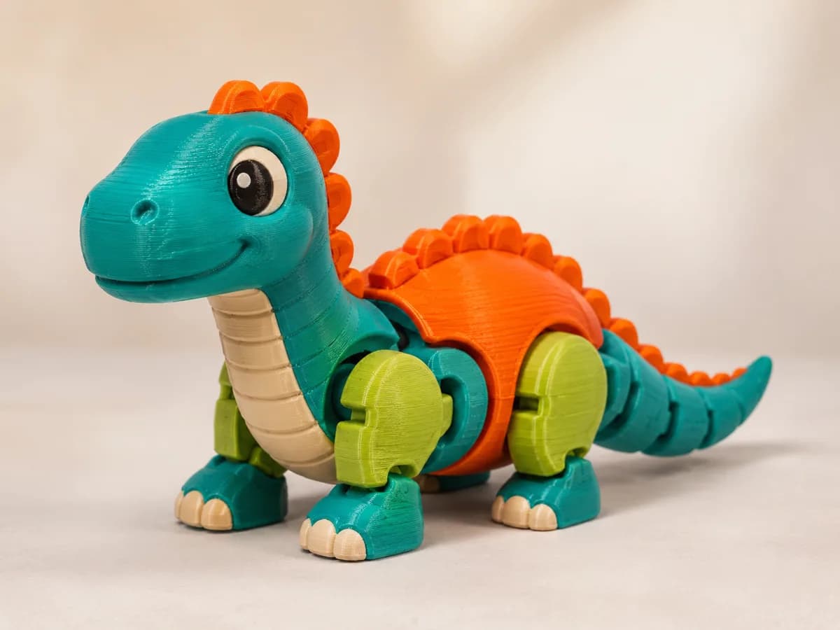 Dinossauro articulado impresso em 3D em verde e laranja